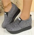 Close-up view of grey wedge platform slip-on sneakers for women shown on model feet. - 35 / Gray