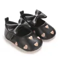 Détail de chaussures de marche pour bébé noires avec broderie cœur et grand nœud. - Noir