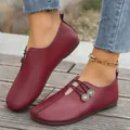 Detailed view of burgundy soft leather flat loafers with decorative buttons - Burgundy