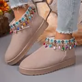 Close-up detail of thick sole snow boots featuring colorful beads and bohemian tassel accents. - Khaki