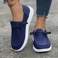 Vue détaillée de mocassins en tissu côtelé bleu marine avec semelles blanches sur asphalte - 36 / Bleu foncé
