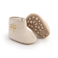 Detail of beige quilted baby winter boots showing anti-slip sole and embroidered bow - Insole Length 11cm / Apricot