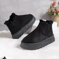 Close-up of black platform snow boots with warm faux fur lining for winter - Black