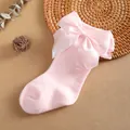 Macro detail view of a soft pink baby knee-high sock featuring a large satin bow - 0-1 Years / Pink