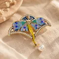 Detailed view of a vintage fairy brooch with colorful enamel wings and a dangling pearl - Drip Oil Fairy (Gold)
