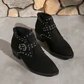 Primer plano de botines negros de punta con tachuelas plateadas y hebilla lateral - Negro