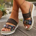 Close-up of bohemian floral wedge sandals with braided straps and espadrille sole. - Black Floral Mesh