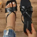 Close-up of black cross-strap flat sandals featuring a modern square toe and slip-on style - 35 / Black