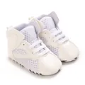 Detailed macro view of white breathable mesh and soft leather baby sneakers - White