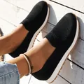 Close-up of black breathable knit slip-on sneakers for women on wooden floor - 36 / Black