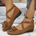 Detail view of brown suede wedge shoes with elegant bow and elastic cross straps - Dark Brown