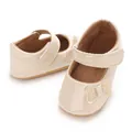 Detailed macro view of glossy beige infant princess shoes with a glitter butterfly. - Apricot