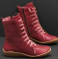 Close-up of red lace-up mid-calf boots with side zipper and flat sole. - 35 / Red