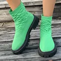 Primer plano de botines calcetín verdes de punto con suela de plataforma negra en madera - 35 / Verde Hierba