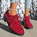 Vista dettagliata di scarpe scamosciate rosse con borchie argentate e lacci alla moda - Rosso