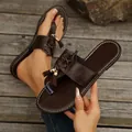 Detailansicht brauner flacher Zehentrenner-Sandalen mit Quasten und Schnürung - Braun