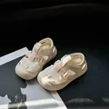 Detailopname van de ademende mesh-kindersandalen met stoffen riempje en klittenband - Beige