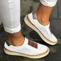 Detail view of white women's platform loafers with colorful stripes and perforated upper. - 35 / White