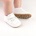 Detailed view of white infant pre-walker shoes featuring non-slip soles and a Velcro strap - 11cm / White