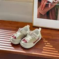 Zapatillas de malla transpirable para niños en beige y burdeos sobre mesa madera - Rosa Fuerte