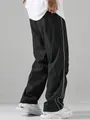 Primer plano de pantalones paracaidistas negros de estilo callejero con rayas blancas - Negro