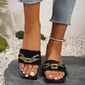 Close-up of black flat slides for women featuring a stylish gold chain and square toe design - Black