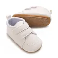 Dettaglio di scarpe da passeggio per neonati bianche con suole antiscivolo e velcro - Bianco