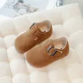 Brown suede children's T-strap shoes with vintage metal buckle on a white cushion. - Camel