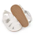 Close-up detail of white baby sandals with soft brown non-slip rubber sole for toddlers - White