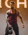 Muscular male model in maroon fitness tank top holding kettlebell in a gym setting - M / Tops / Red