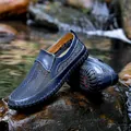 Detailopname van ademende blauwe mesh herenloafers op natuurlijke natte rivierrotsen - 38 / Blauw