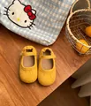 Zapatos de princesa amarillos de ante para niñas pequeñas sobre mesa de madera - Amarillo