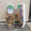 Detail view of vibrant bohemian printed canvas sneakers with sparkling gold laces. - 36 / Rainbow