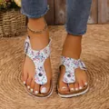 Nahaufnahme von Damen-Strandsandalen mit floralem Print, bequemer Korksohle und Schnalle - Beige
