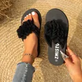 Détail de tongs d'été noires avec de grandes fleurs en tissu 3D et semelle à logo - Noir