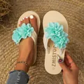 Détail de tongs à fleurs vert menthe avec des semelles plates confortables pour l'été chic - Cyan
