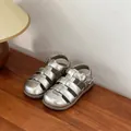 Close-up of shiny silver baby girl sandals with closed toe and soft sole for summer - Silver