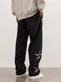 Detail view showing the back of black street-style joggers with white star embroidery. - Black