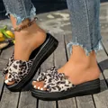 Sandalias con plataforma y lazo de leopardo en pies de modelo sobre deck madera. - Estampado de Leopardo Gris