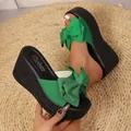 Detailed close-up of green wedge sandals featuring a large stylish decorative bow - 34 / Green