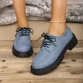 Close-up of women's blue denim platform Oxford shoes with thick black lug soles - 35 / Blue