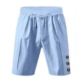 Detail view of light blue linen shorts featuring drawstring waist and decorative buttons. - Light Blue