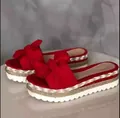 Close-up of red platform sandals featuring a large bow and straw woven sole - 35 / Red