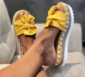 Close-up of yellow bow platform slides with woven hemp rope and white jagged sole. - 35 / Yellow