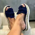 Detailed view of women's navy blue bow wedge sandals featuring a braided hemp rope platform. - Blue