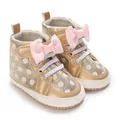 Detailansicht goldener Babyschuhe mit rosa Schleifen und weißem Punktmuster-Design - Gold