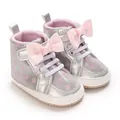 Detailansicht silberner Baby-Lauflernschuhe mit rosa Punkten und dekorativen Schleifen - Silber