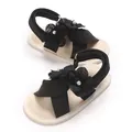 Gros plan de sandales noires pour bébé avec fleurs en tissu, perles et semelle souple. - 11cm / Noir