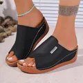 Detailed side view of comfortable black wedge slides with white stitching and tan soles - 36 / Black