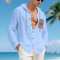 Close-up detail of a men's light blue bohemian linen hooded shirt with beach background - S / Tops / Light Blue